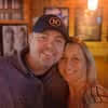 Smiling man and woman posing closely together indoors with warm lighting.